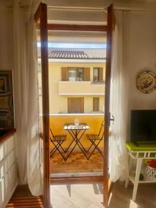 a door leading to a balcony with a table outside at CLhome: 3 minuti dal mare in Alghero