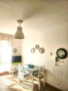a dining room with a table and chairs and clocks on the wall at CLhome: 3 minuti dal mare in Alghero