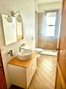 a bathroom with a sink and a toilet and a window at CLhome: 3 minuti dal mare in Alghero