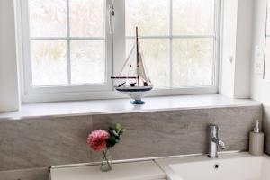 a vase with a sail boat on a window ledge at Leap House in Wareham +32 photos