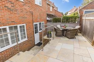 a patio with a table and chairs next to a brick building at Leap House in Wareham
