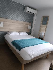 1 dormitorio con 1 cama con cabecero de madera en Fasthôtel Clermont-Ferrand Gerzat en Gerzat