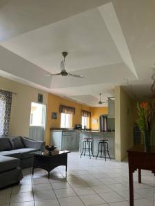 a living room with a couch and a kitchen at Kay Marni: Your Saint Lucian home in Gros Islet