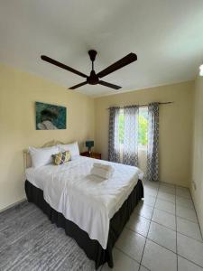 Schlafzimmer mit einem großen Bett und einem Deckenventilator in der Unterkunft Kay Marni: Your Saint Lucian home in Gros Islet