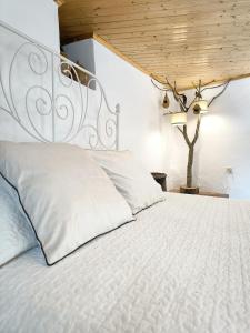 a bedroom with a white bed with a wooden ceiling at Canastro Nature Spot in Viseu