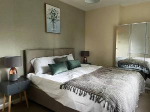 - une chambre avec un grand lit et des oreillers verts dans l'établissement Spacious 4bed With Private Parking, à Lincolnshire