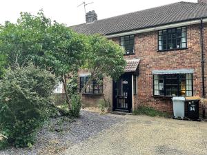 une maison en briques avec un arbre devant elle dans l'établissement Spacious 4bed With Private Parking, à Lincolnshire