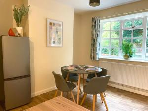 d'une salle à manger avec une table, des chaises et une fenêtre. dans l'établissement Spacious 4bed With Private Parking, à Lincolnshire