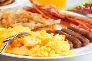 a plate of breakfast food with sausage and eggs at Renaissance Fort Lauderdale West Hotel in Plantation