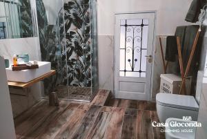 a bathroom with a shower and a toilet and a door at Bed and Breakfast Casa Gioconda in Gaeta