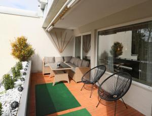 eine Terrasse mit Stühlen, einem Tisch und einem Sofa in der Unterkunft Premium 106 m2 Wohnung Top für München/Oberbayern in Geretsried