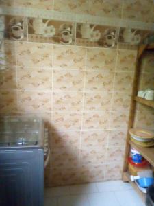 un baño con una pared de azulejos con tazas. en Maison Manour, chambre 'Tribal', en Mbour