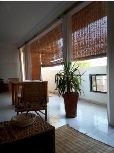 a living room with a table and a potted plant at Maison Manour, chambre 'Tribal' in Mbour