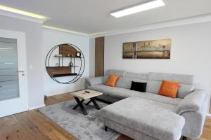 ein Wohnzimmer mit einem Sofa und einem Tisch in der Unterkunft Premium 106 m2 Wohnung Top für München/Oberbayern in Geretsried