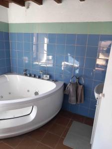 baño de azulejos azules con bañera blanca en ΠΕΤΡΟΚΤΙΣΤΟ, en Kakopetria