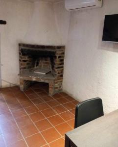 a brick fireplace in a room with a table and chairs at ΠΕΤΡΟΚΤΙΣΤΟ in Kakopetria