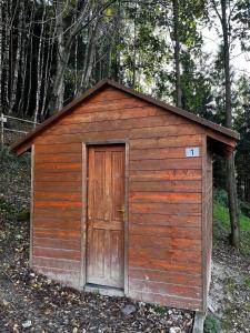 a small wooden shed with a door in the woods at Ubytování na Horečky Ranči in Nový Jičín