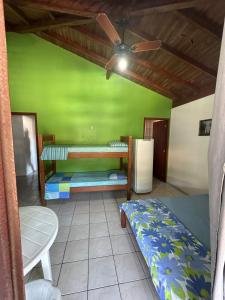 ガロパバにあるPousada Via Ferrugemの二段ベッド2台、冷蔵庫が備わる客室です。