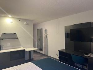 a room with a bed and a flat screen tv at Studio 6 Suites Norcross, GA in Norcross