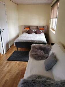 1 dormitorio con 1 cama y 1 sofá en Līdumnieki en Vērgale