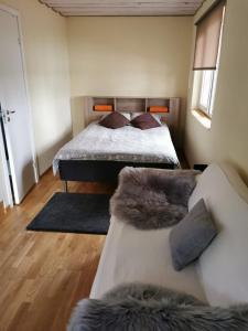 a bedroom with a bed and a couch at Līdumnieki in Vērgale