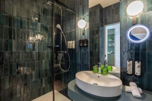 a bathroom with a sink and a shower at voco Brussels City North by IHG in Vilvoorde +179 photos