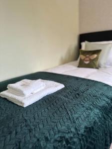 een paar handdoeken bovenop een bed bij 3 Bed House - Parking - Pool Table - Close to A1 in Balderton
