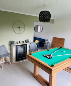 een woonkamer met een pooltafel en een open haard bij 3 Bed House - Parking - Pool Table - Close to A1 in Balderton