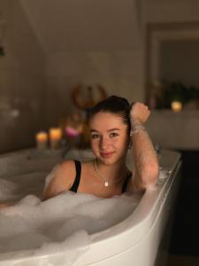 Eine Frau sitzt in einer Badewanne in der Unterkunft Poeziya Mandriv in Schidnyzja