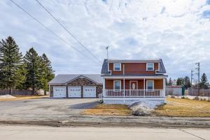 una casa grande con garaje en una calle en Spacious Presque Isle Home Walk to Downtown!, en Presque Isle