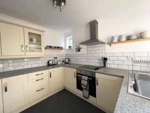 a kitchen with white cabinets and a sink at Spacious 5-bed - Perfect For Contractors 