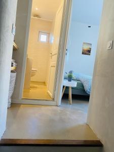 een gang met een deur die naar een slaapkamer leidt bij Les Logis de la Combette in Saint-Rémy-de-Provence