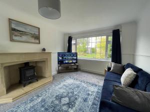 salon z niebieską kanapą i telewizorem w obiekcie Spacious 5-bed - Perfect For Contractors 