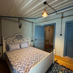 艾瓦勒克的住宿－Eolya Konuk Evi，一间设有床铺的卧室,位于一间拥有蓝色墙壁的房间