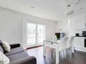 ein Wohnzimmer mit einem Sofa, einem Tisch und Stühlen in der Unterkunft 3 bedroom penthouse with balcony in London