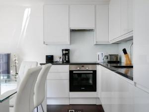 eine weiße Küche mit weißen Geräten und weißen Schränken in der Unterkunft 3 bedroom penthouse with balcony in London