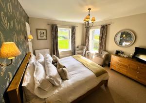 A bed or beds in a room at Ravenstone Lodge Country House Hotel