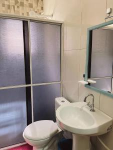 a bathroom with a toilet and a sink at Pousada da Maira in Foz do Iguaçu