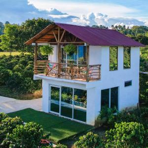 une maison avec un balcon au-dessus dans l'établissement Mirador del Magdalena Hotel y Glamping, à Isnos