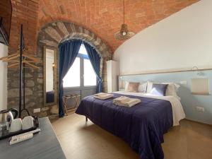 a bedroom with a bed and a brick wall at Casale 1541 in Bolsena