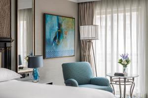 a hotel room with a bed and a blue chair at Intercontinental Cairo Citystars by IHG in Cairo