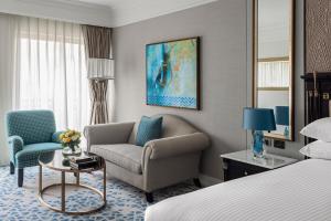 カイロにあるインターコンチネンタル カイロ シティスターズのベッド、ソファ、椅子が備わるホテルルームです。