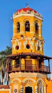 un edificio amarillo con una torre con balcón en Cómodo Apartamento céntrico, en Mompox