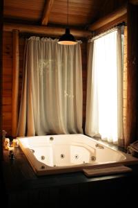 uma grande banheira sentada em frente a uma janela em Hospedaria Refugio do Invernador em Urubici