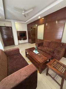 a living room with a couch and a coffee table at Tipsyy Inn & Suites Jaipur in Jaipur
