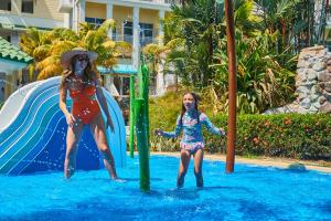 dos chicas jugando en un tobogán de agua en un resort en Gran Evenia Bijao - All Inclusive, en Playa Blanca