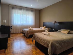 a hotel room with two beds and a window at Hotel Santa Barbara in Andorra