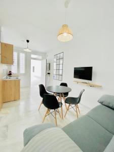 un soggiorno con divano, tavolo e sedie di SOLEO suite a Jerez de la Frontera