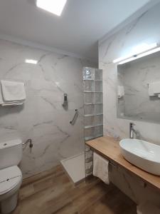 een witte badkamer met een toilet en een wastafel bij Hotel Solatorre in Comillas
