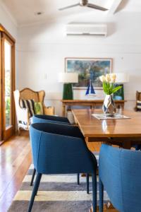 uma sala de jantar com uma mesa de madeira e cadeiras azuis em Denham Heights em Townsville